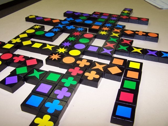 Et fremskredent spil Qwirkle. Hvis en spiller lige havde lagt de 5 firkanter i billedets højre side, så havde hun fået 2 (de 2 firkanter) + 12 (de 6 orange symboler) + 5 (de 5 firkanter) = 19 point.