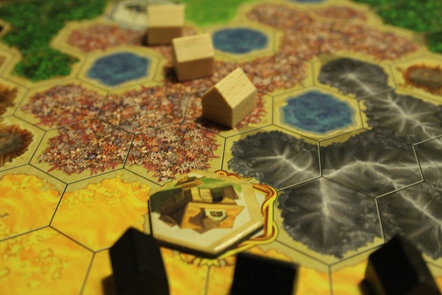 Den sorte spiller i Kingdom Builder placerer sine hus op til et saf de specielle felter og tager en af beliggenhedsbrikkerne fra feltet.
